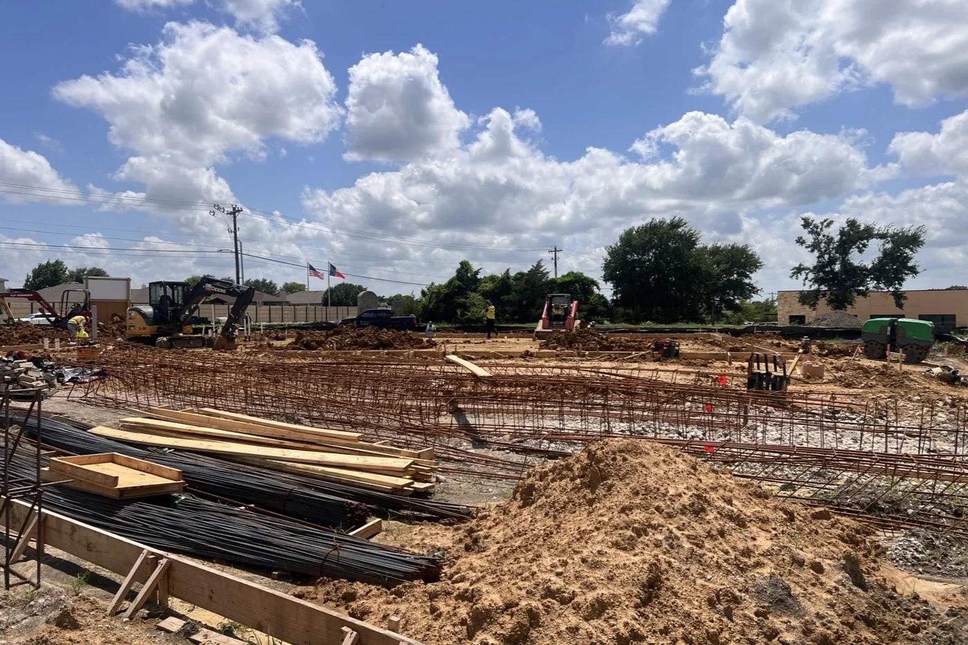 Foundation work at the Anna site in June 2026, with reinforcing steel set in formwork and excavated ground around it.