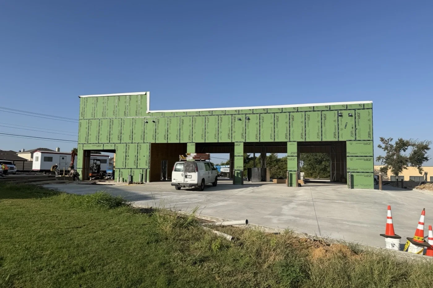 The Anna facility in September 2026 seen head on, with a row of open service-bay openings running the length of the building.