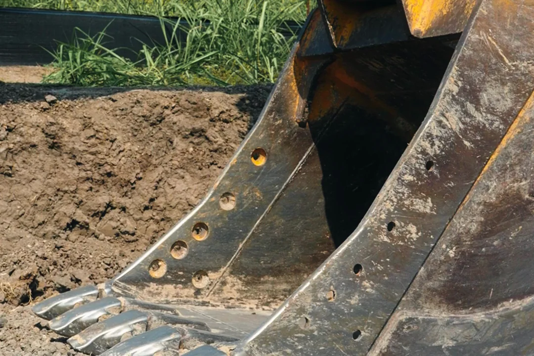 Close view of an excavator bucket resting on excavated ground at the Wylie site.